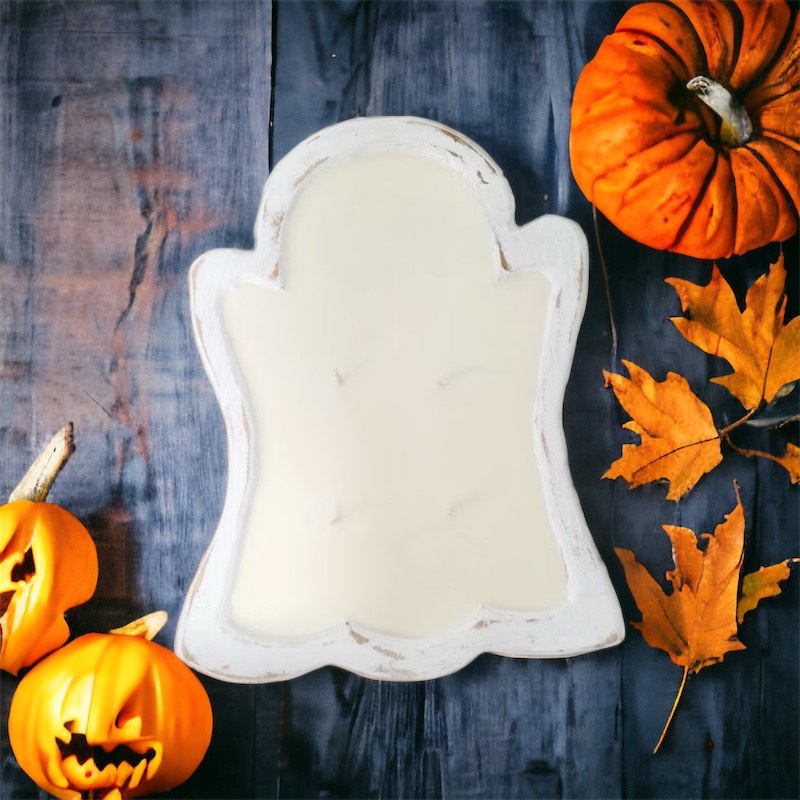 Ghost shaped candle with fall decor on a wood table
