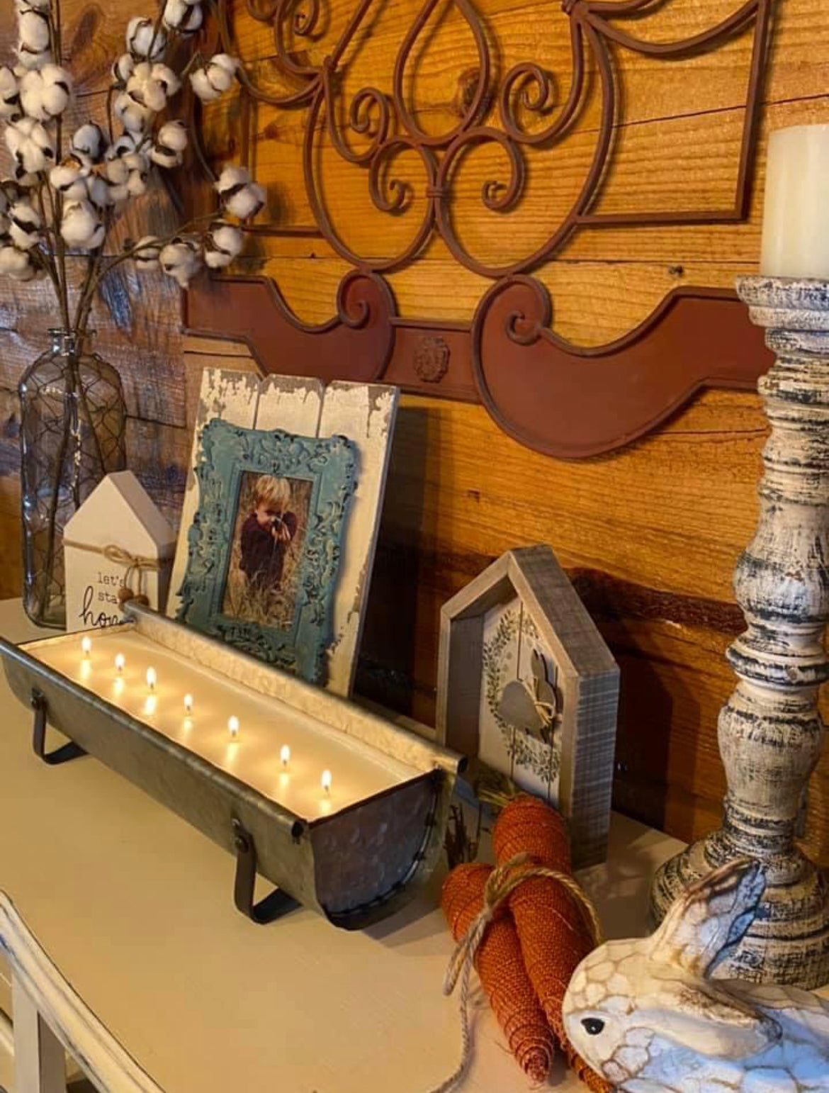long metal candle on a shelf with other rustic decor