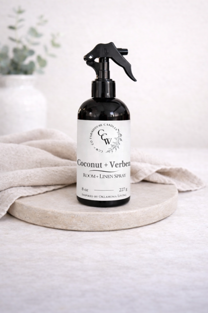 Coconut + Verbena room and linen spray bottle on a light surface with a neutral background