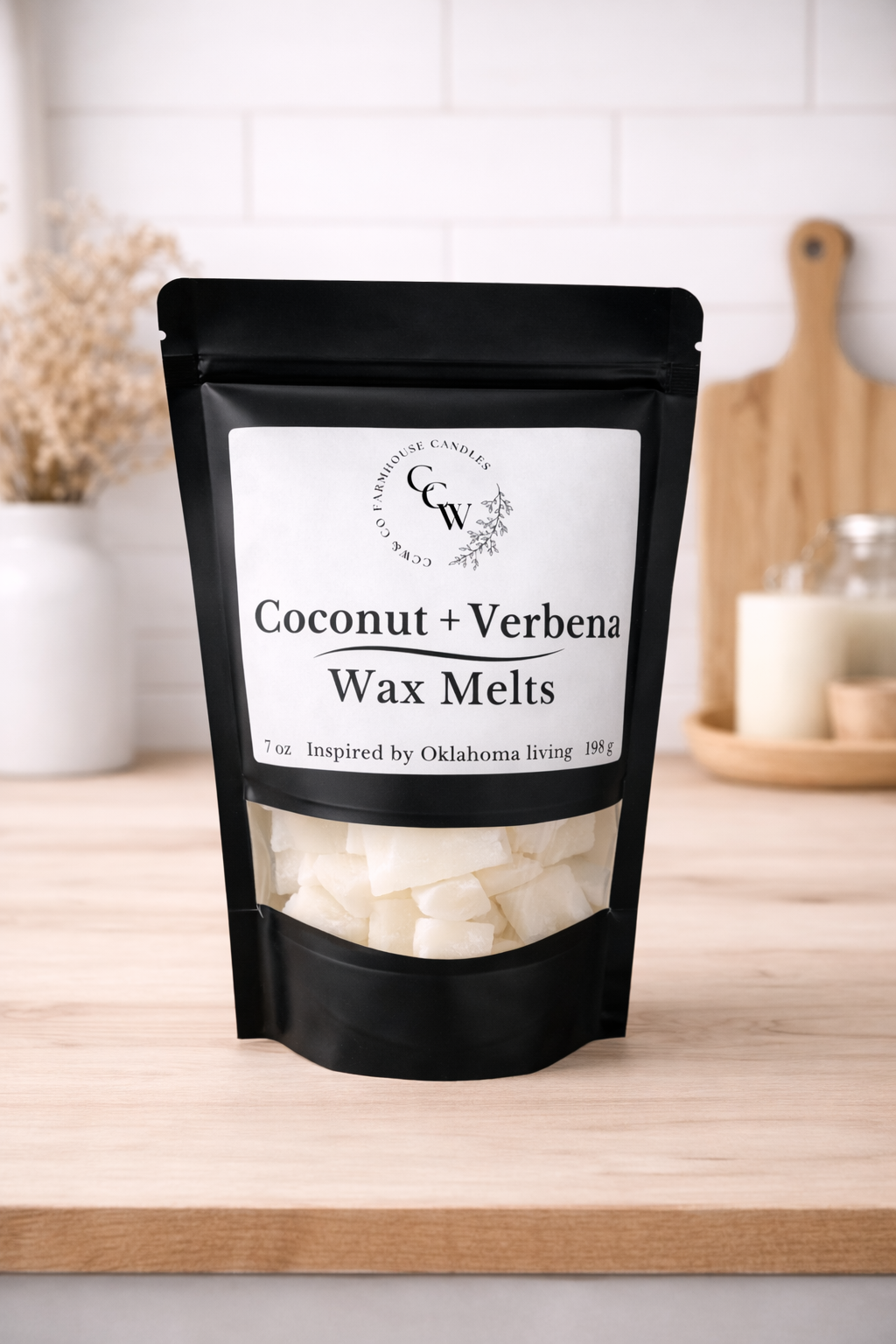 Black resealable pouch of Coconut + Verbena wax melts by CCW & Co Farmhouse Candles, featuring a white label and clear window showing hand-poured wax melts, styled on a neutral kitchen countertop.