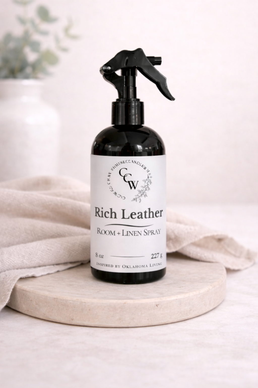 Rich Leather room and linen spray bottle on a light surface with a neutral background