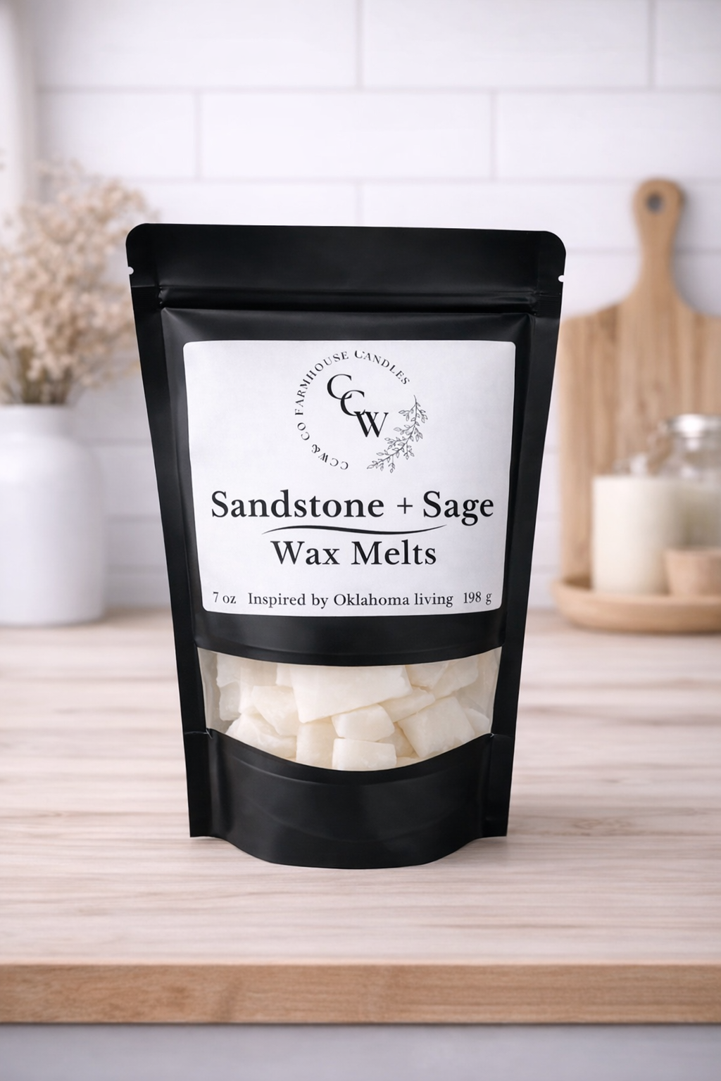 Black resealable pouch of Sandstone + Sage wax melts by CCW & Co Farmhouse Candles, featuring a white label and clear window showing hand-poured wax melts, styled on a neutral kitchen countertop.
