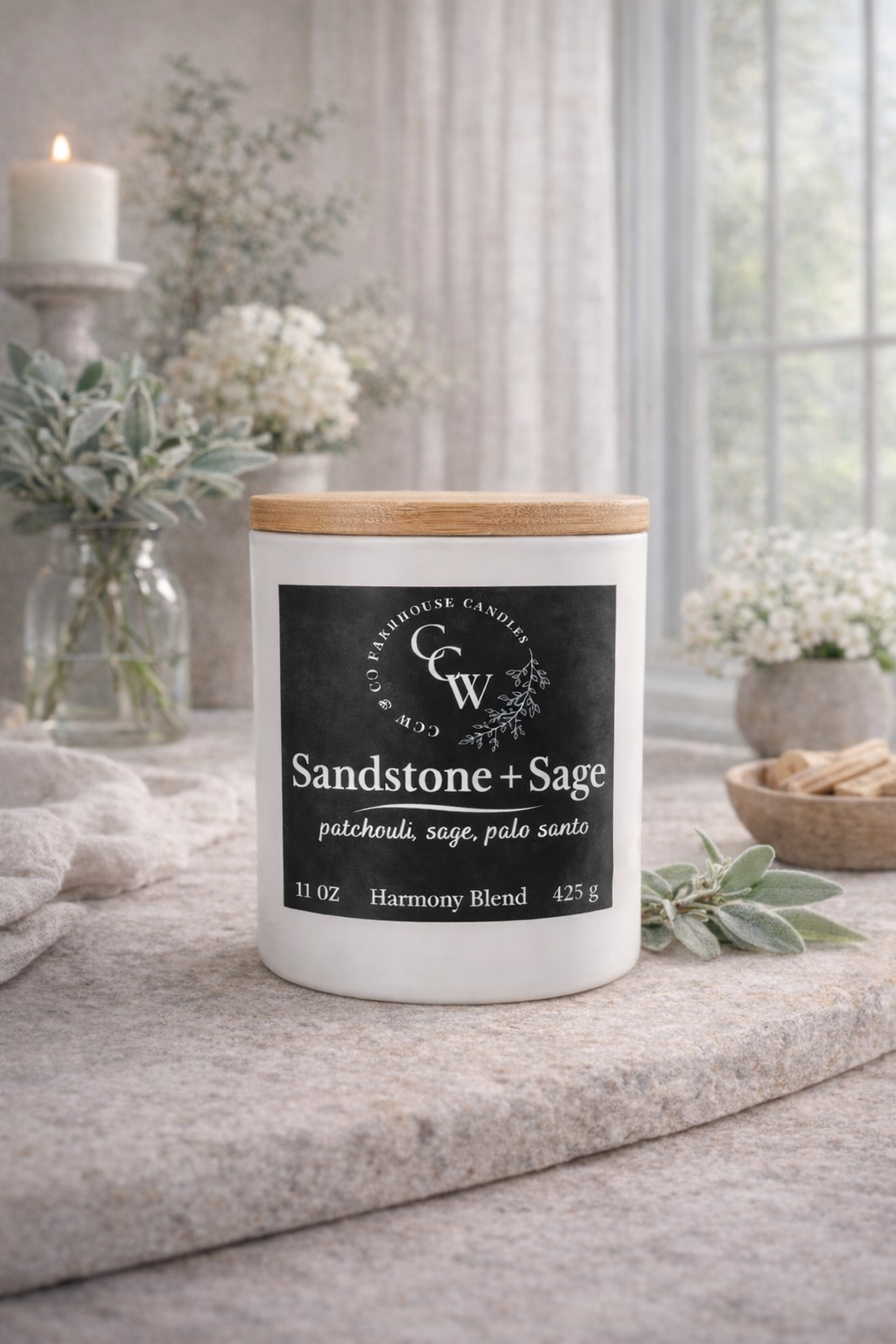 Sandstone + Sage candle by CCW & Co Farmhouse Candles in a white jar with wooden lid, styled on a neutral tabletop in soft natural light