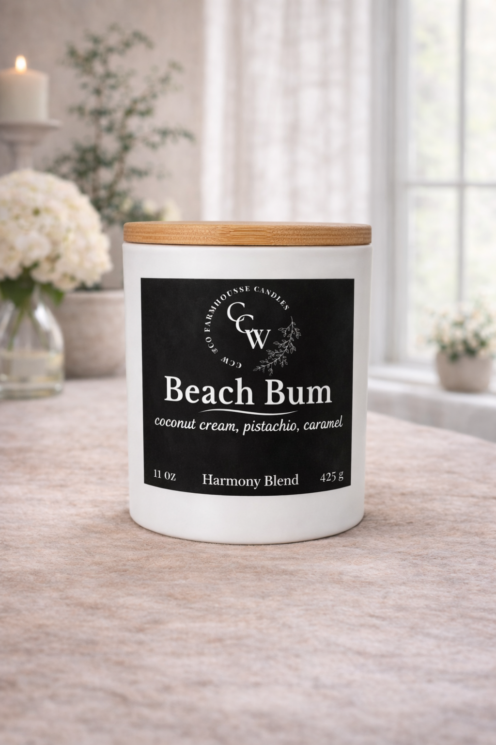 Beach Bum candle by CCW & Co Farmhouse Candles in a white jar with wooden lid, styled on a neutral tabletop in soft natural light