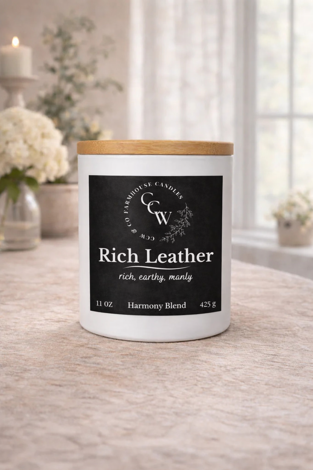 Rich Leather candle by CCW & Co Farmhouse Candles in a white jar with wooden lid, styled on a neutral tabletop in soft natural light